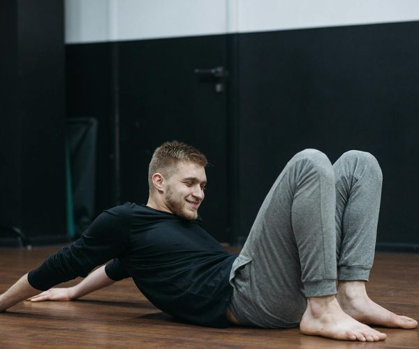 Man stretching on a mat as part of his routine.